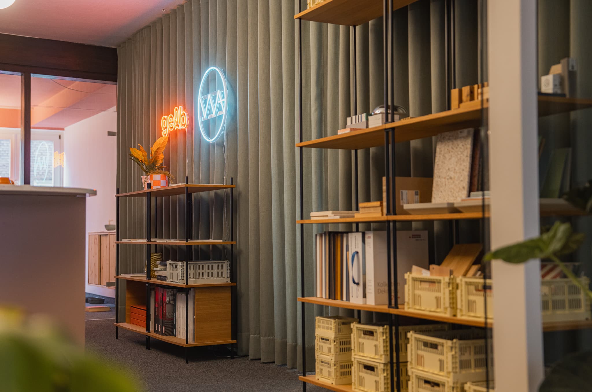 Lobby mit KUUDU Standregal, Neon-Logo WA, Blick ins Büro