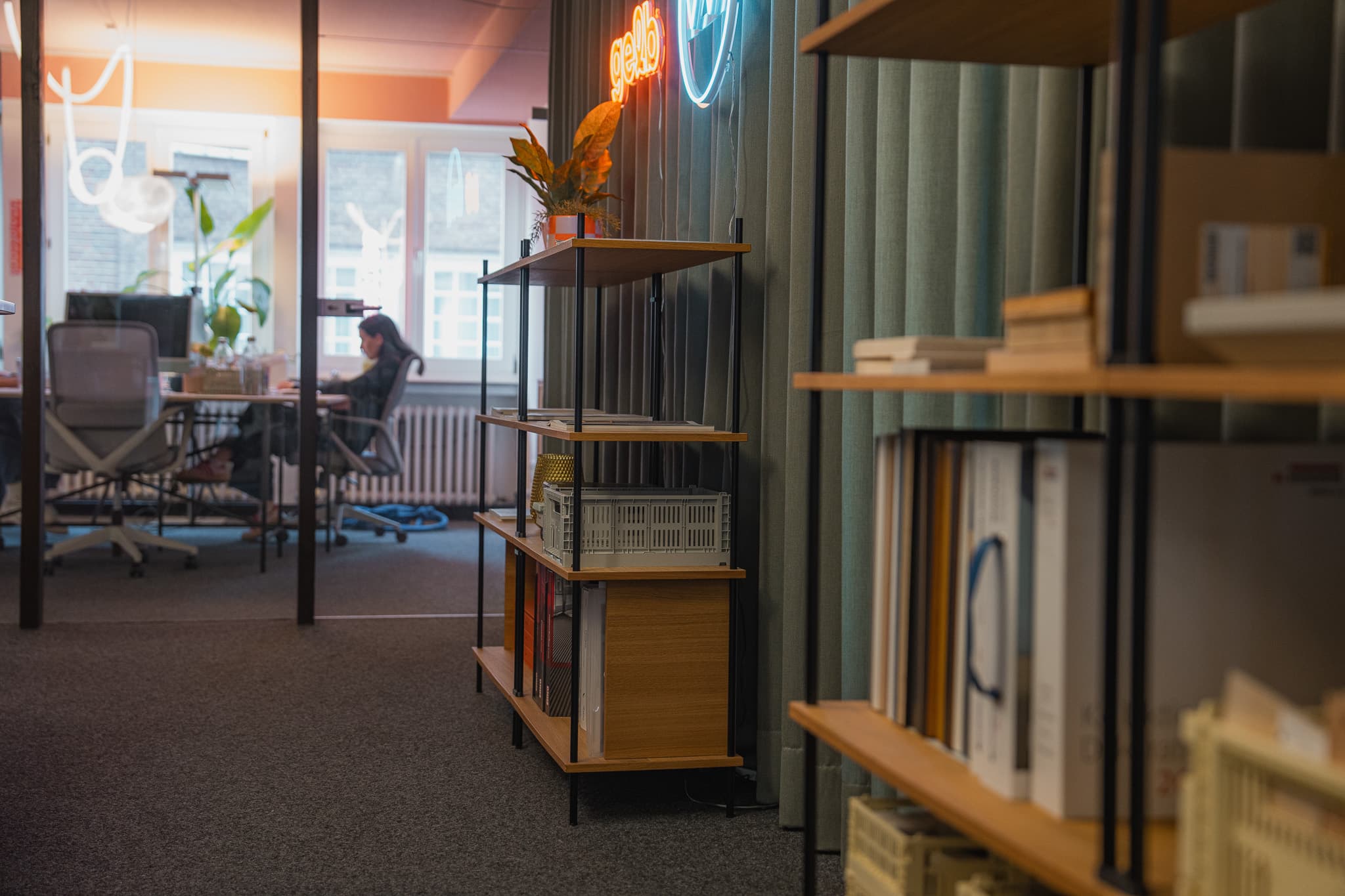 KUUDU Standregal in der Lobby, Büro mit Arbeitsplätzen im Hintergrund