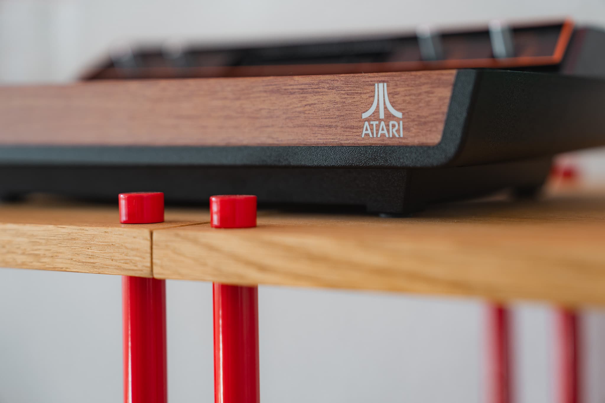Atari 2600+ auf einem KUUDU Regal in Eiche, Stangen und Kappen in Atari-Rot