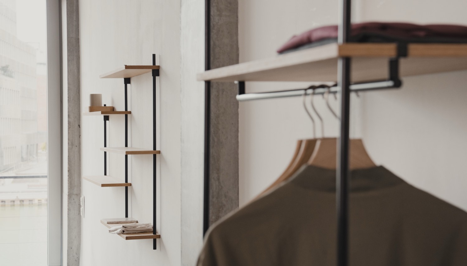 Bright dressing room with a KUUDU clothes rail and a narrow wall shelf by the window